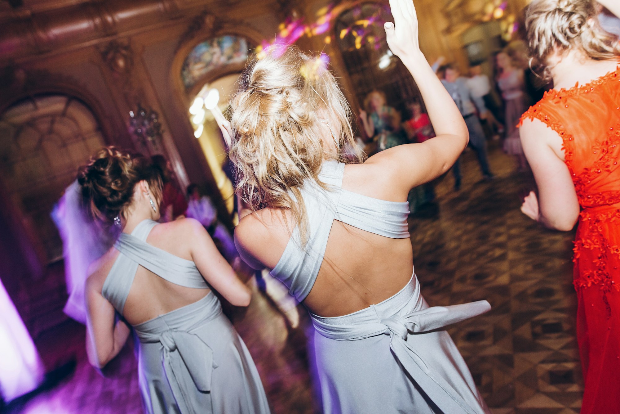 Guests dancing in light, people in motion at party in club