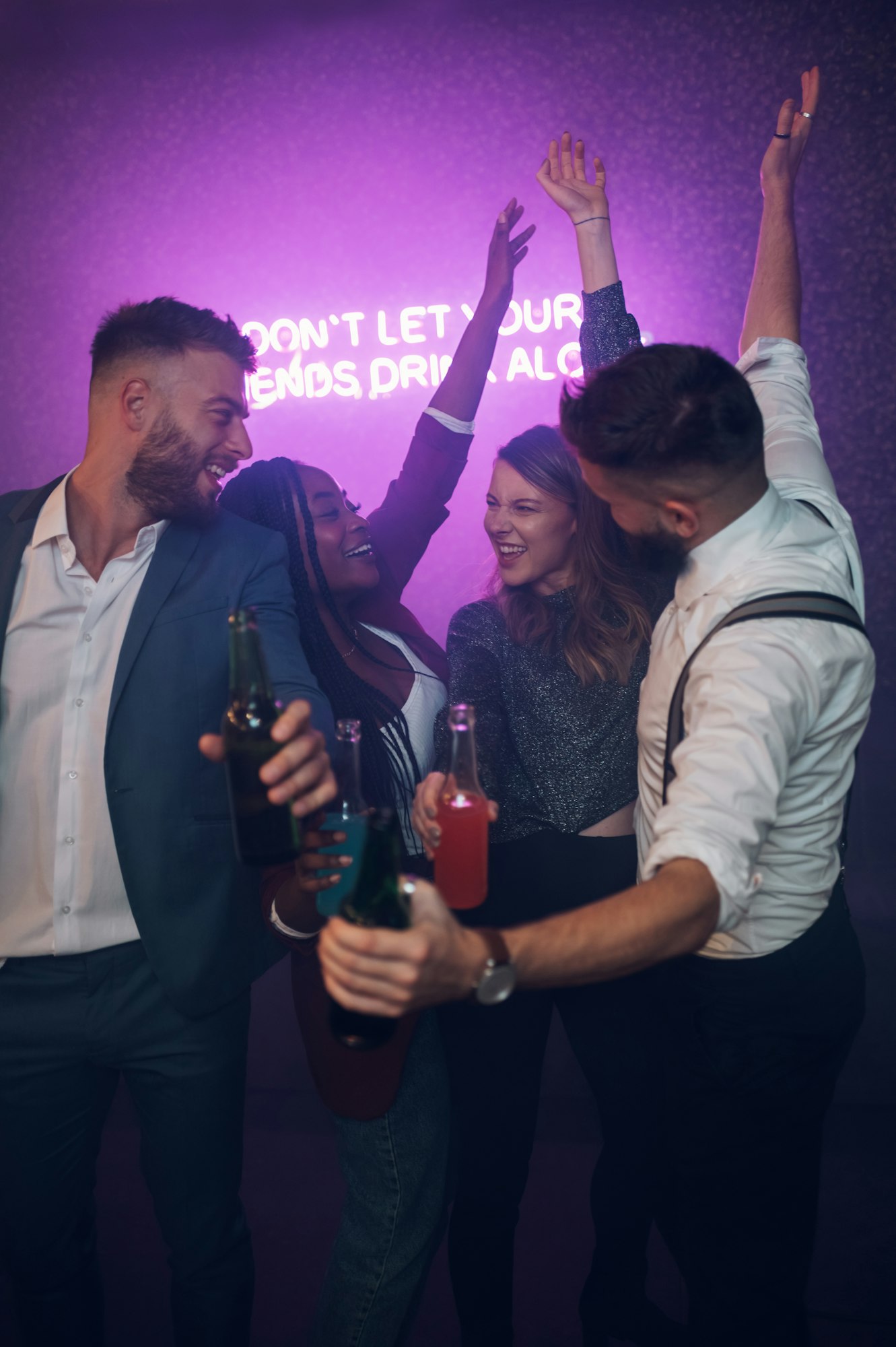 Happy group of friends dancing on a party in a club